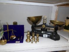 A set of kitchen scales with weights and a cased set of precious metal scales.