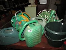 A quantity of watering cans, hose pipes etc.