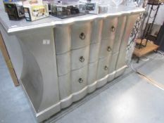 A silver coloured chest of drawers.