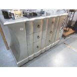 A silver coloured chest of drawers.