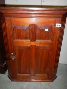 A small mahogany corner cupboard.