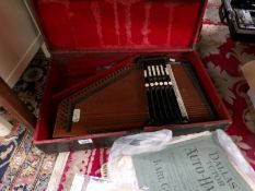 A Zimmermann's autoharp with distressed case.