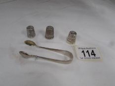 3 silver thimbles and a pair of silver sugar tongs.