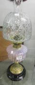 A Victorian oil lamp with glass font and later shade.