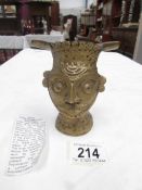 A 19th century Indian cast bronze head of the God Shiva with foliate and scroll decoration,