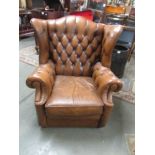 A tan leather wing armchair.