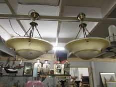 A pair of brass and glass uplighter ceiling lights.