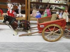 A pottery horse pulling a sack trailer.