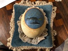 An early 20thC ostrich egg depicting a naive folk art image of a boat at sea,