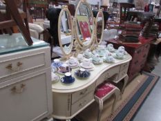 A cream dressing table and stool.