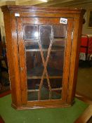 An oak astragal glazed corner cabinet.