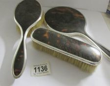 A 3 piece silver rimmed dressing table set with faux tortoise shell backs.