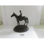 A bronze figure of a race horse and jockey.