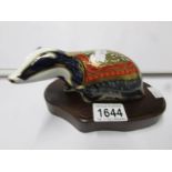 A Royal Crown Derby paperweight, Badger on wooden stand.