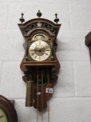 An oak and brass wall clock.