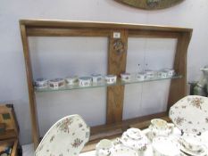 An Ercol swan shelf unit with glass shelves.