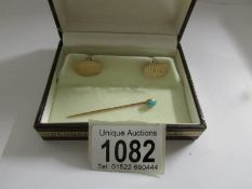 A boxed pair of 9ct gold cuff links and a gold coloured stick pin set turquoise