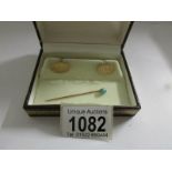 A boxed pair of 9ct gold cuff links and a gold coloured stick pin set turquoise