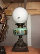 A Victorian oil lamp with painted glass font and complete with shade and chimney.