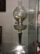 An Edwardian oil lamp with silver base complete with shade and chimney.