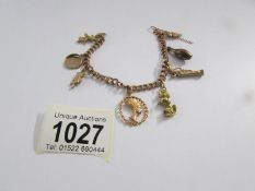 A 9ct gold charm bracelet with gold and yellow metal charms, total weight 19 grams.