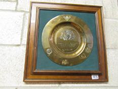 A framed brass presentation plaque.