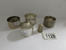 4 silver napkin rings and a silver thimble, all hall marked.