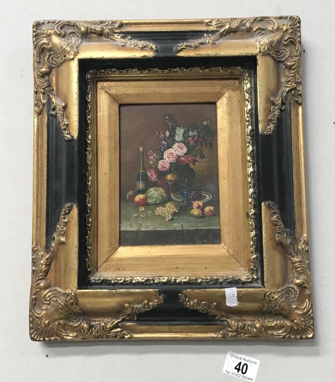 A gilt framed floral picture.