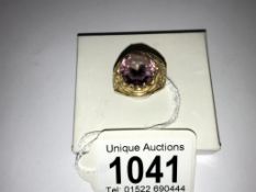 A gold ring with fretwork shoulders set large possibly amethyst, size M.