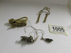 A miniature metal cat chasing mouse, an unusual brass dog and a puzzle key.