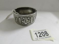 A Victorian silver cuff bangle, heavily worked with flowers and foliage, dated Birmingham 1891.
