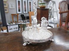 A silver plate and glass condiment set.