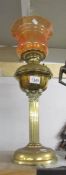 A brass Corinthian column oil lamp with shade and chimney.