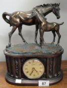 A mantel clock surmounted horse with foal.