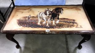 A coffee table with picture of shire horses in top signed G Cunhill.