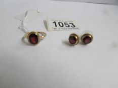 A 9ct gold ring set garnet and a pair of matching earrings.