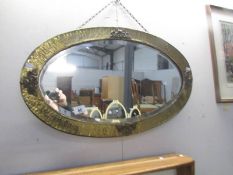 A brass framed oval bevel edged mirror.