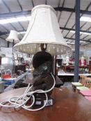 A carved wood table lamp with shade.