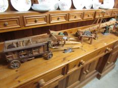 A quantity of hand made wooden models of farm implements and trailers.