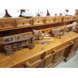 A quantity of hand made wooden models of farm implements and trailers.