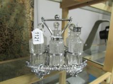 A 6 bottle Victorian cruet on silver plated stand, missing one stopper.