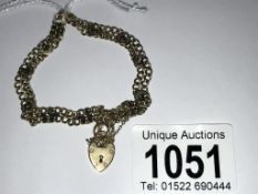 A unusual 9ct gold gate bracelet with intermittent gold horse shoes, padlock and safety chain,
