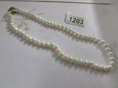 A cultured pearl necklace with stone set clasp.