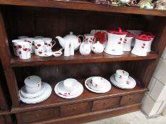 2 shelves of poppy decorated table ware.