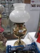 A brass oil lamp with shade but missing chimney.