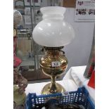 A brass oil lamp with shade but missing chimney.