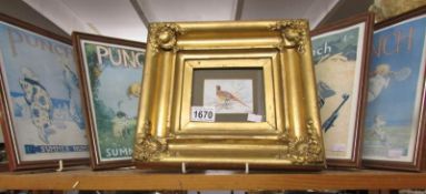 A gilt framed pheasant picture and 4 framed and glazed Punch front pages.
