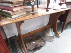 An oak dining table on stretcher base.