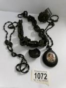 A Whitby jet pendant with hand painted porcelain portrait, a 'choker' chain, a horseshoe brooch,