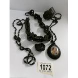 A Whitby jet pendant with hand painted porcelain portrait, a 'choker' chain, a horseshoe brooch,